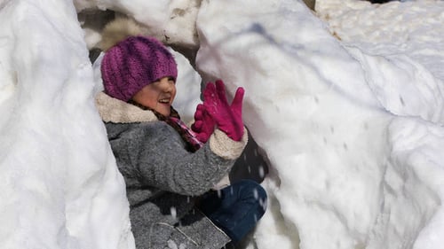 Child Playing, Throwing Snowballs in Winter Snow Fort