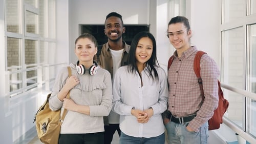 Smiling Students Giving Thumbs Up in School Hallway