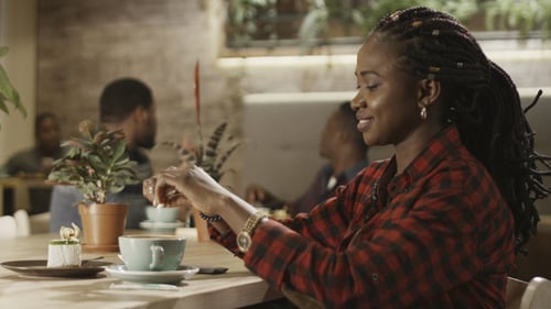A Beautiful Black Girl Pours Sugar Into Coffee