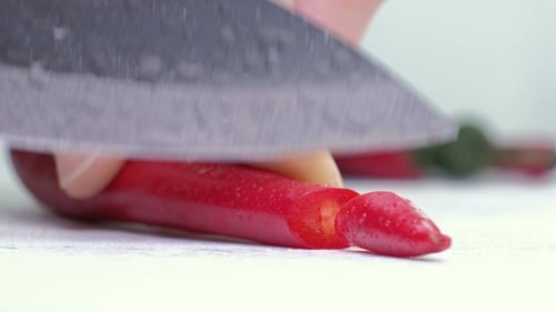 Red Peppers on Cutting Board and Knife on White Background.