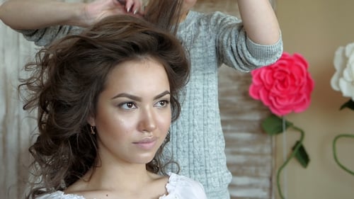 Maskenbildner-Stylist arbeitet mit Model. Der Friseur macht das Haarstyling des Models.