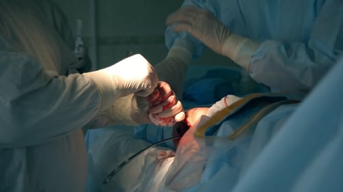 Surgeons perform operation in a bright operating room