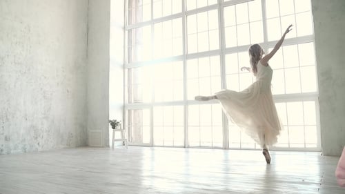 Elegant Ballerina Dancing Gracefully in White Studio