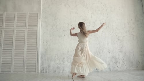 Elegant Woman Dancing Ballet in White Studio