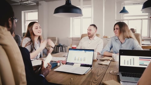 Young Female Employee Presents Project at Office Team Meeting. Happy Young Colleagues Discuss