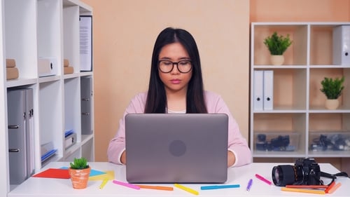 Woman Smiling Working at Laptop in Office