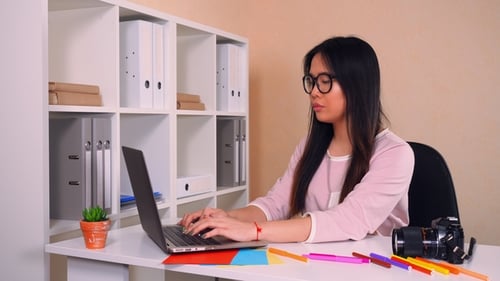 Woman Typing on Laptop at Desk