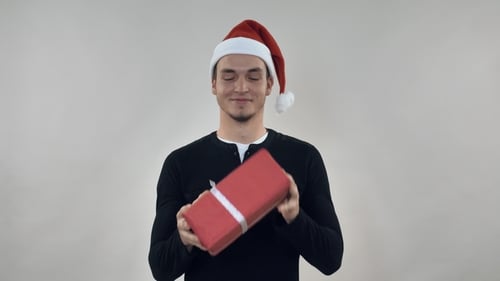 Young Adult Shakes Christmas Gift with Joy
