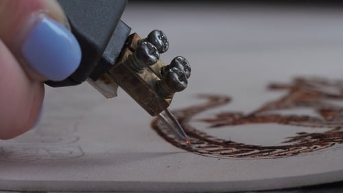 Woman Uses a Device for Burning on Natural Leather. Creating and Decorating of Handmade Wallet or