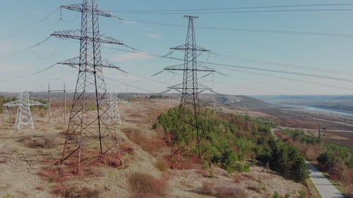 Electric High Voltage Pylon Against Sky. Aerial View From Drone To Power Lines. Nature Landscape