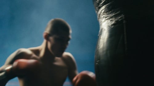 Man Training with Punching Bag in Gym
