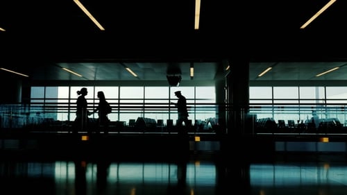 Silhouetten der Passagiere im Flughafenterminal. Sie fahren auf einem sich bewegenden Riemen