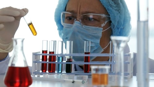 Scientist Examining Test Tubes in Laboratory Setting