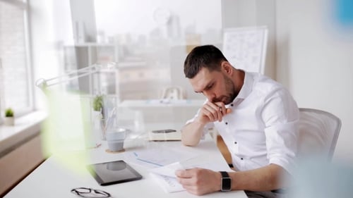 Geschäftsmann mit Tablet-PC und Papieren im Büro 9