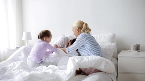 Playful Family Giggles in Bed in the Morning