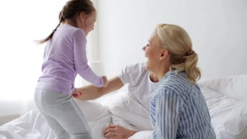 Joyful Family Playing Together on Bed at Home
