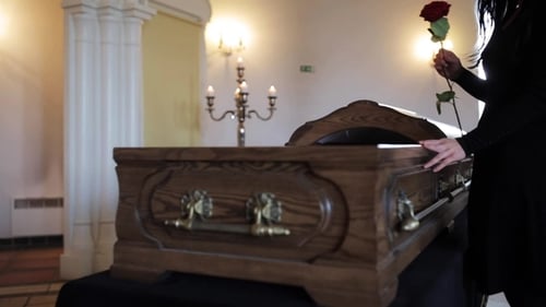 Woman Places Rose on Coffin in Remembrance