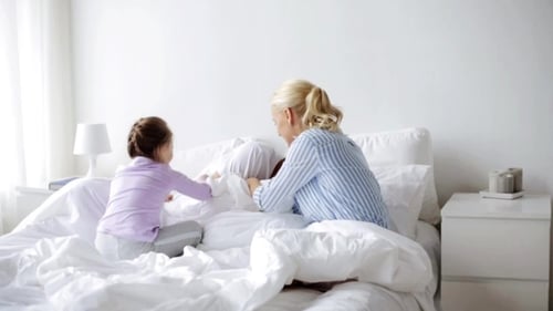Family Playtime Together on Bed in Bright Bedroom