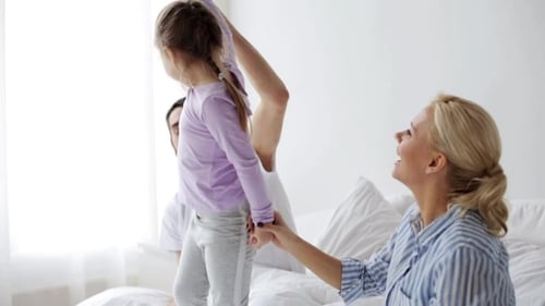 Family Fun with Child Jumping on Bed