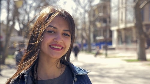 Pleasant and Happy Girl Smiles in a Street on a Sunny Day in Slo-mo