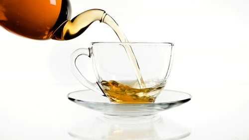 Tea Pouring in the Cup Isolated on White