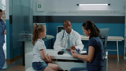 Doctor Consults with Child and Mother in Clinic