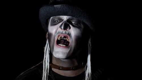 Frightening Man in Skeleton Halloween Costume Appearing From Darkness When Light Falls on Him