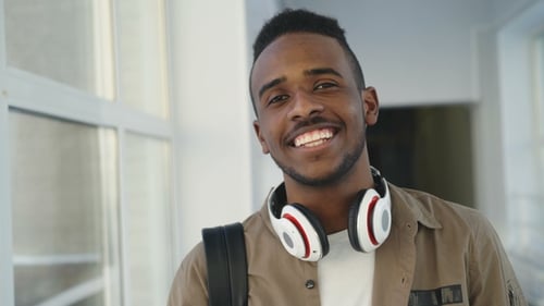 Young Man Smiling at Camera in School Hallway
