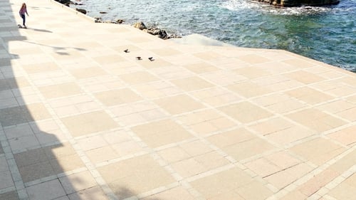 A Girl Is Riding on an Empty Embankment on Skateboard