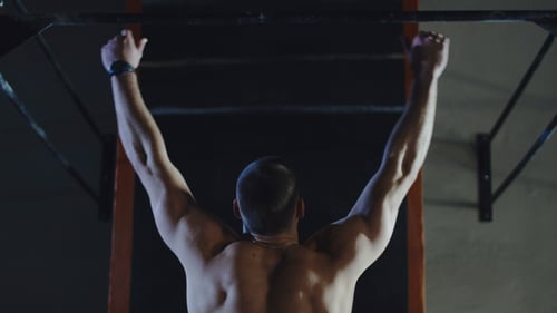 Muscular Sportsman with Shirtless Torso Doing Chin-ups