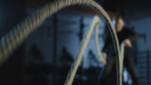 Athlete Working Out with Heavy Ropes in Gym