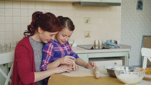 Woman and Girl Baking Cookies Together in Kitchen