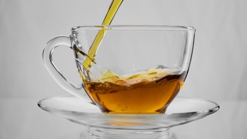 Tea Being Poured into a Glass Teacup