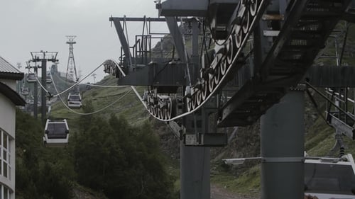 Cable Car Cabin Riding Over Green Trees in Rocky Mountains