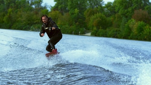 Man Riding Board on Waves. Wake Boarding Rider Training on Wakeboard Boat