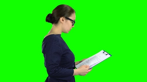 Woman Comes with a Paper Tablet on the Street
