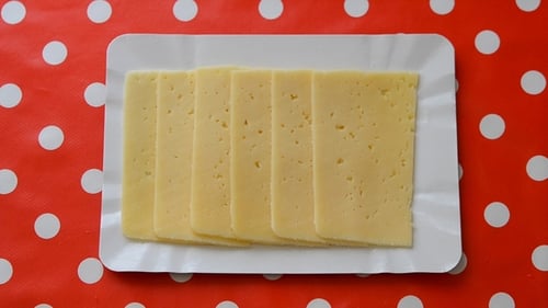 Person Taking Slices of Cheese. Top View.
