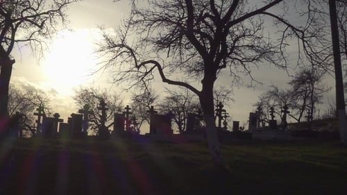 Old Graveyard with Ancient Crosses at Sunset. Scary Cemetery
