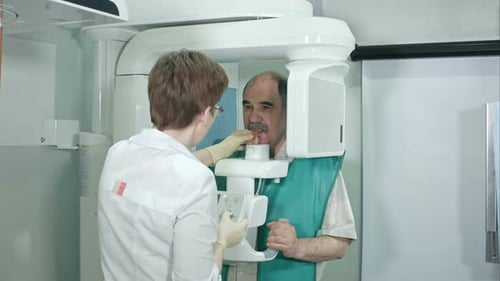 Junge Zahnärztin bereitet Patientin auf Analysen eines zahnärztlichen Panorama-Röntgenfilms in der Klinik vor