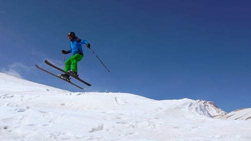 Skier Jumps on Snowy Mountain Slope