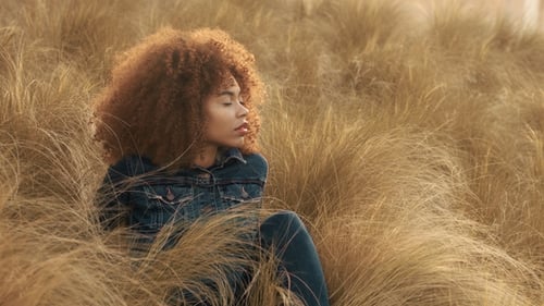 Black Mixed Race Woman with Big Afro Curly Hair in Lawn Field with High Dry Autumn Hay Grass and
