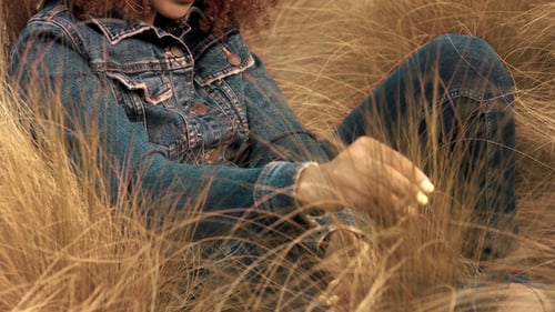 Black Mixed Race Woman with Big Afro Curly Hair in Lawn Field with High Dry Autumn Hay Grass and