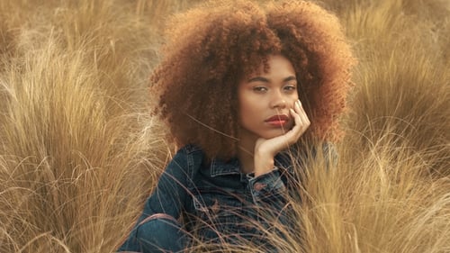 Black Mixed Race Woman with Big Afro Curly Hair in Lawn Field with High Dry Autumn Hay Grass and