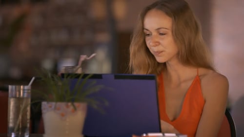 Woman Works Using Laptop Drinking Cocktail in Cafe