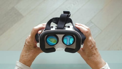 Senior Woman Is Putting On White VR Glasses Virtual Reality Point Of View Taking Of VR Glasses
