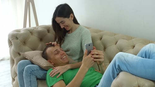 Loving Couple Relaxing on the Couch with Phone