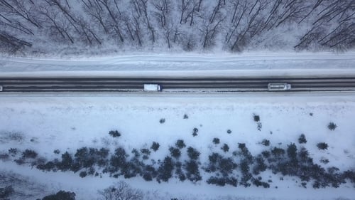 Cars Driving Through Winter Forest Road.