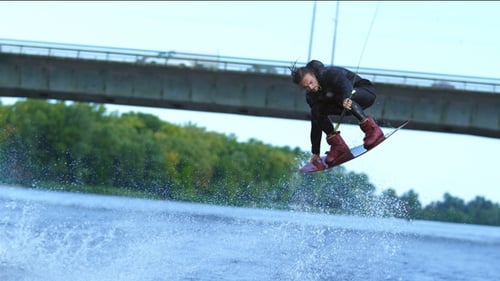 Athlete Wakeboarder Jumping High Above Water. Extreme Stunt Over Water
