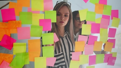 Women Brainstorming with Adhesive Notes in Office