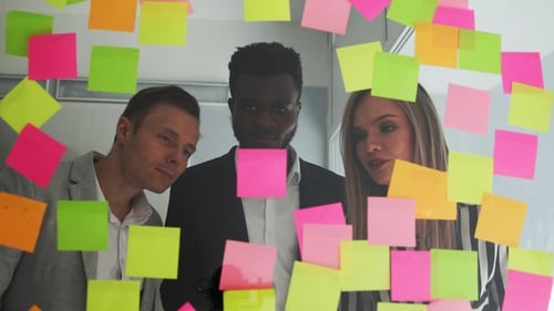 Team Brainstorming Ideas Using Sticky Notes in Office